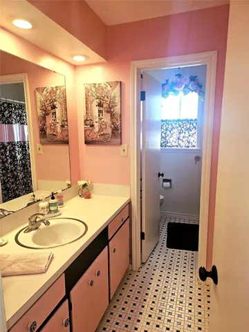 a bathroom with a sink a toilet a shower and a window