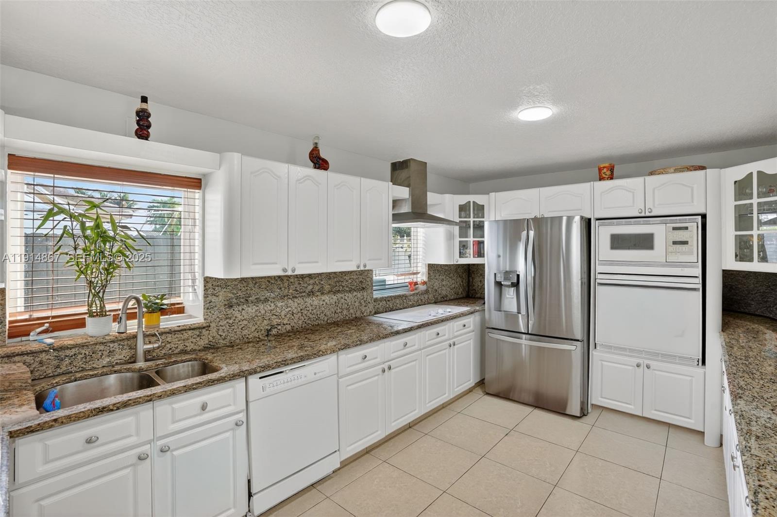 9835 Southwest 26th Terrace Miami, FL 33165 - Photo 12 of 48 a kitchen with granite countertop a refrigerator and a sink