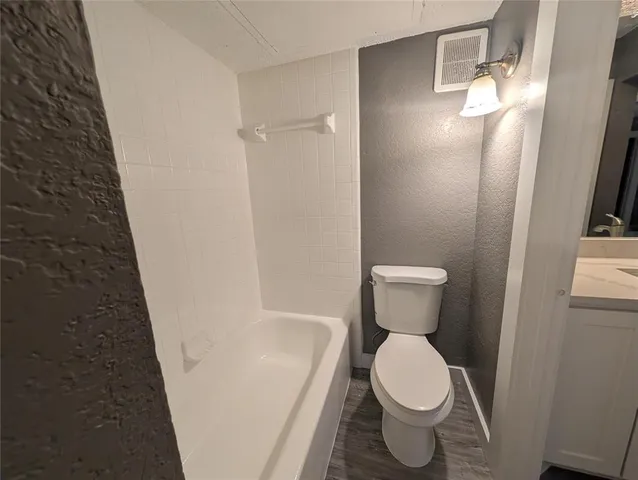 a white toilet sitting next to a white sink