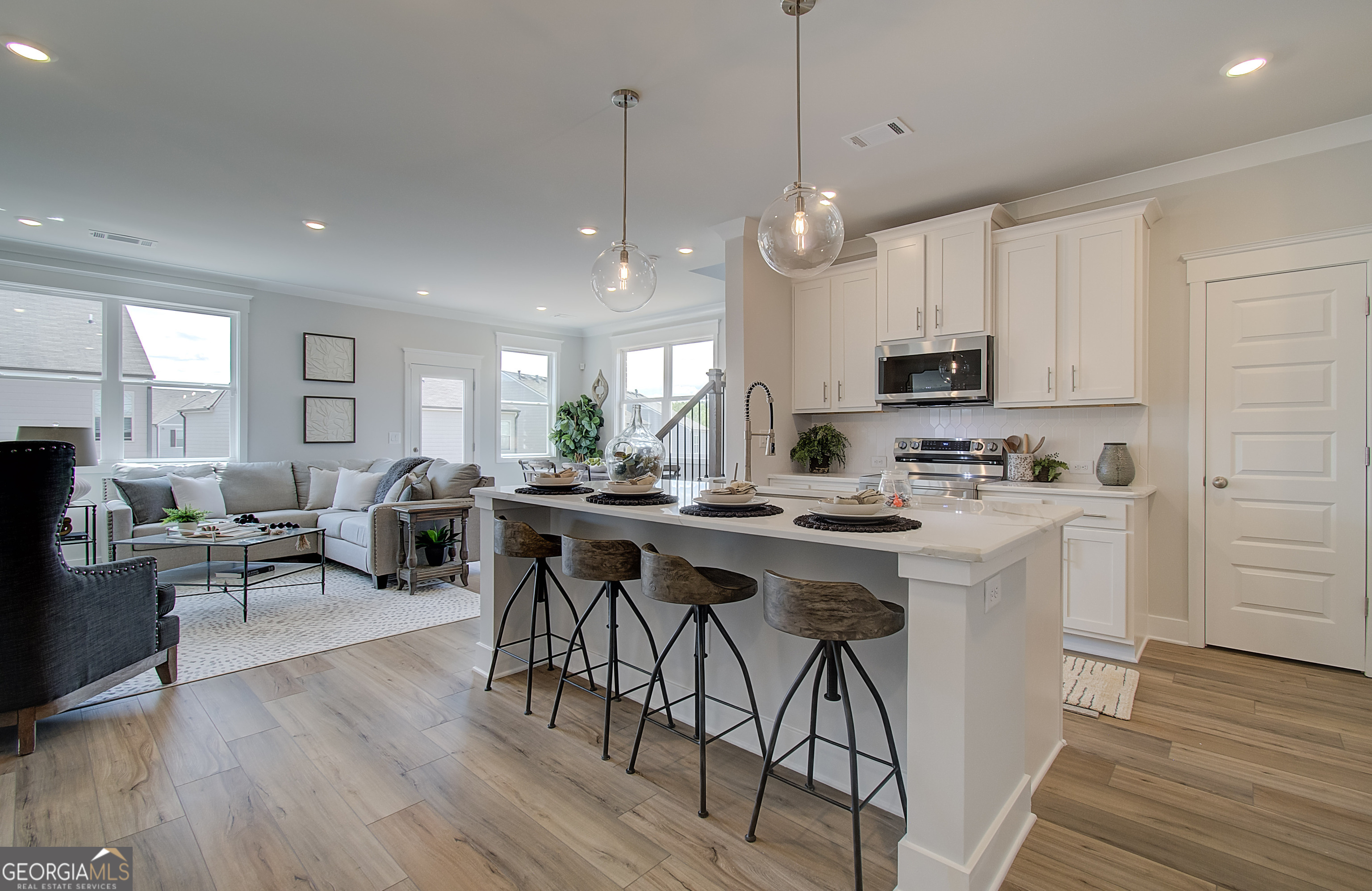 179 Depot Landing Road, Unit 27A Auburn, GA 30011 - Photo 4 of 38 a kitchen with stainless steel appliances kitchen island granite countertop a stove a sink a oven a dining table and chairs with wooden floor