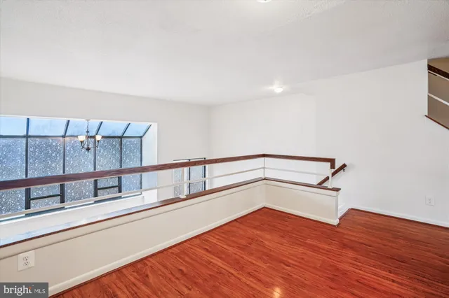 a view of a hallway with wooden floor and stairs