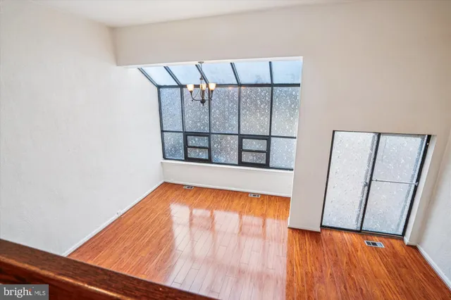 a view of an empty room with wooden floor