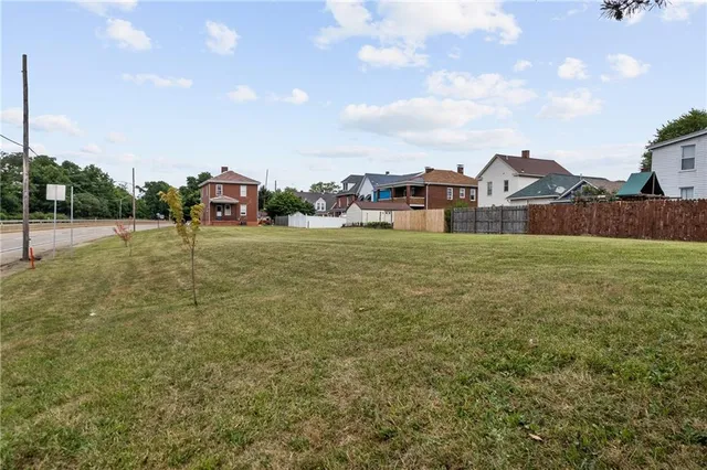 a view of a house with a big yard and large trees