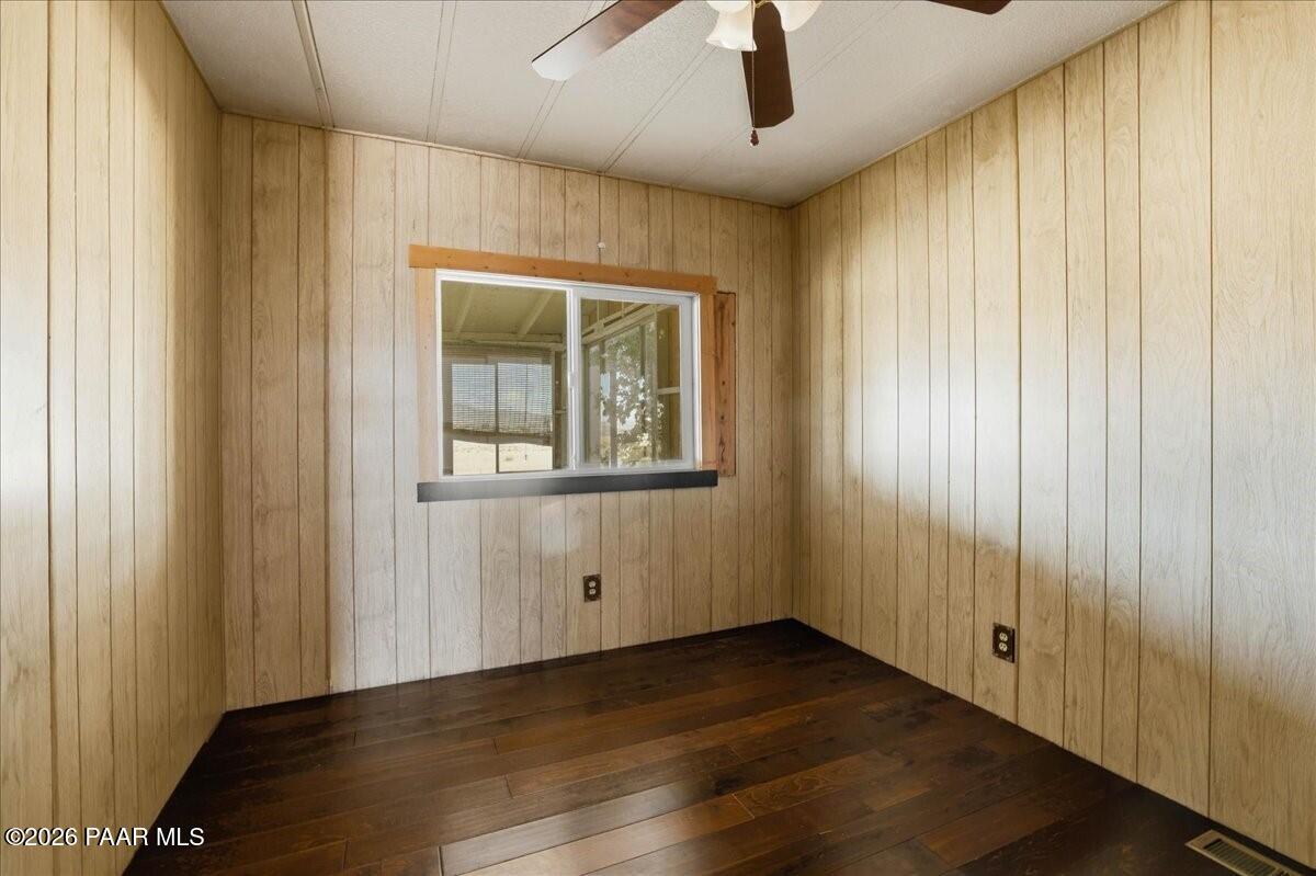 192 North Outback Road Dewey, AZ 86327 - Photo 12 of 25 an empty room with wooden floor chandelier fan and windows