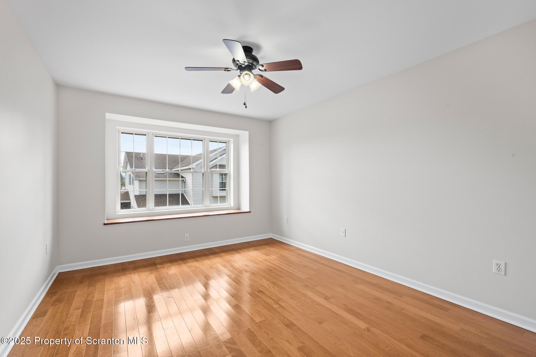 609 Edith Street Old Forge, PA 18518 - Photo 16 of 25 a view of an empty room with wooden floor and a window