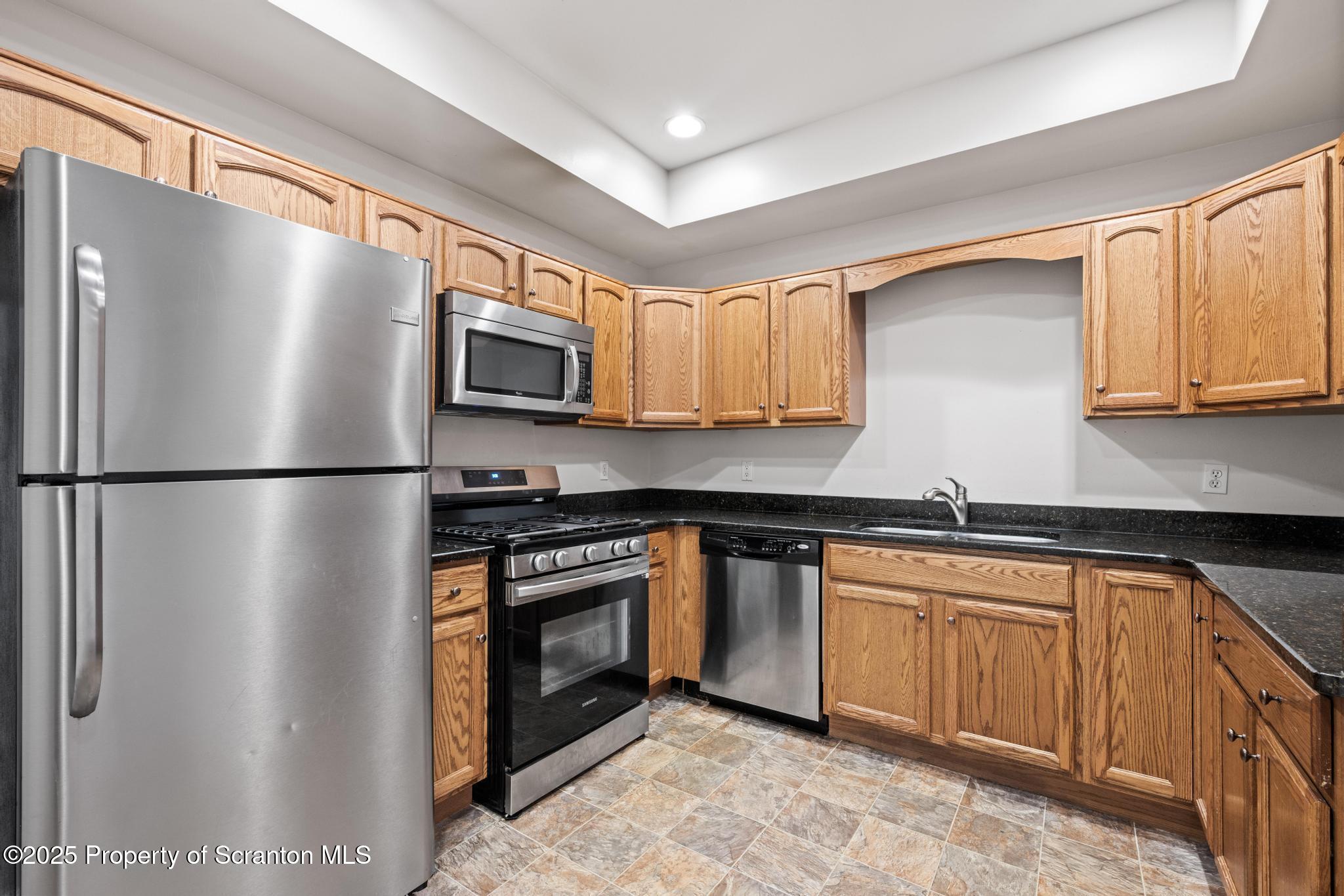 609 Edith Street Old Forge, PA 18518 - Photo 5 of 25 a kitchen with stainless steel appliances granite countertop a refrigerator a stove a sink and a microwave