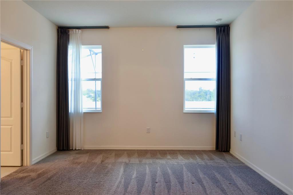 2164 Carriage Pointe Loop Apopka, FL 32712 - Photo 22 of 30 an empty room with wooden floor and windows