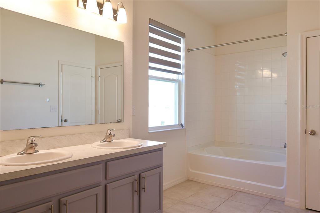 2164 Carriage Pointe Loop Apopka, FL 32712 - Photo 27 of 30 a bathroom with a bathtub and a sink