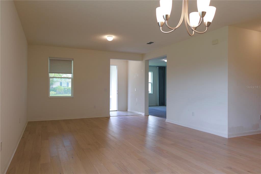 2164 Carriage Pointe Loop Apopka, FL 32712 - Photo 5 of 30 a view of an empty room with wooden floor and a window