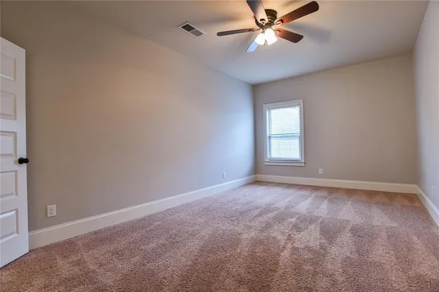 a view of an empty room with a ceiling fan