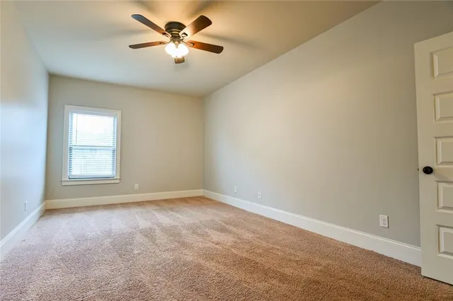 an empty room with wooden floor fireplace and windows