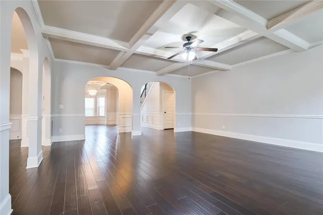 an empty room with wooden floor fireplace and windows