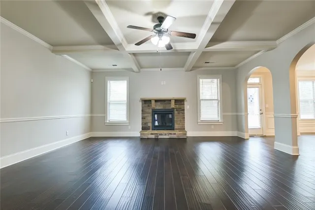 a kitchen with stainless steel appliances kitchen island granite countertop a stove a refrigerator a sink a microwave oven with wooden floor and cabinets