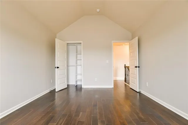 a view of a hallway with wooden floor and windows