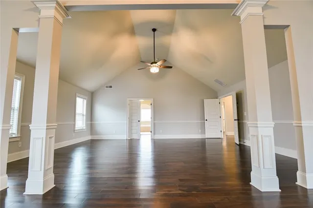 a view of a hallway with wooden floor and a bathroom