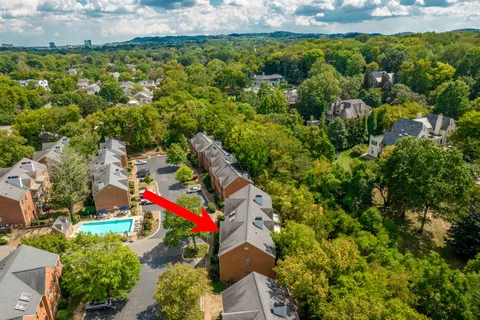 an aerial view of a houses with a yard and lake