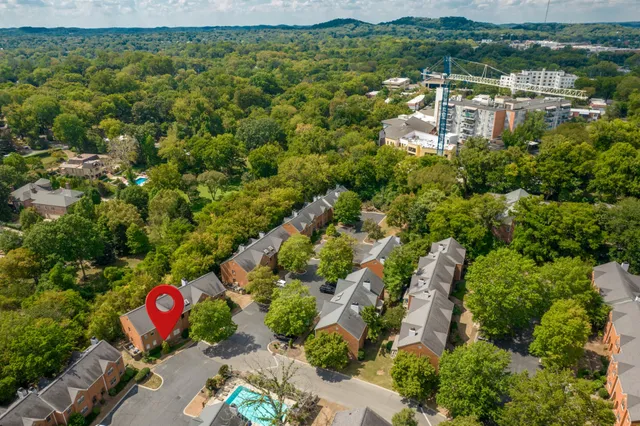 an aerial view of residential houses with outdoor space and trees