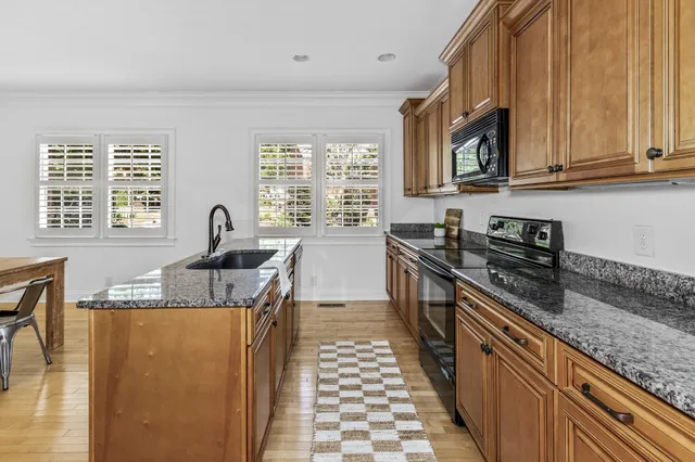a kitchen with stainless steel appliances granite countertop a sink and a stove