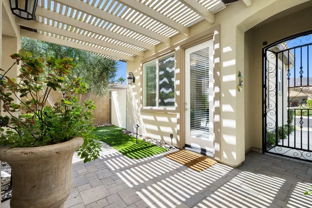 a view of a patio with table and chairs potted plants and palm trees