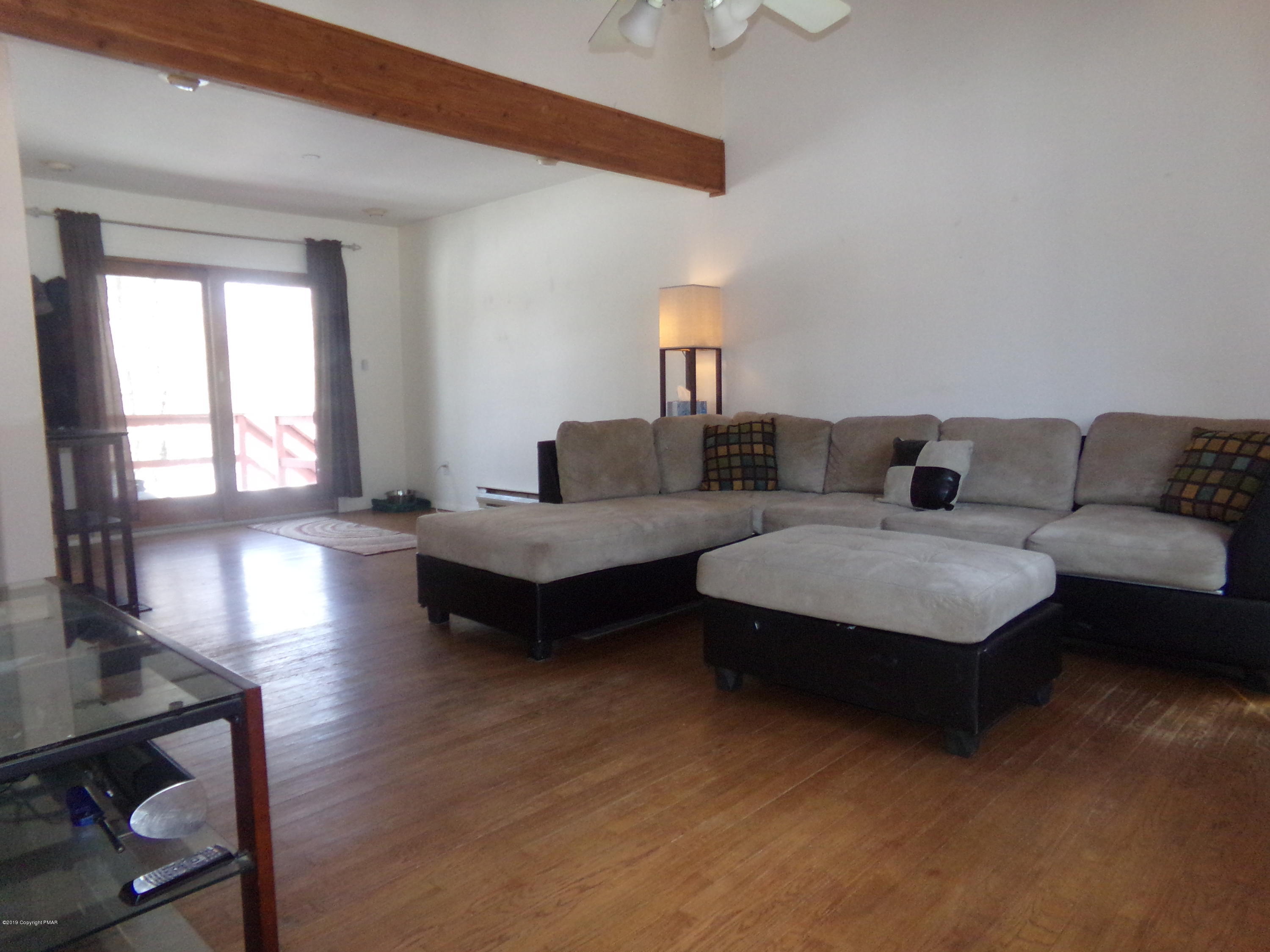 1193 Bear Drive Bushkill, PA 18324 - Photo 13 of 29 a living room with couches and a dining table with wooden floor