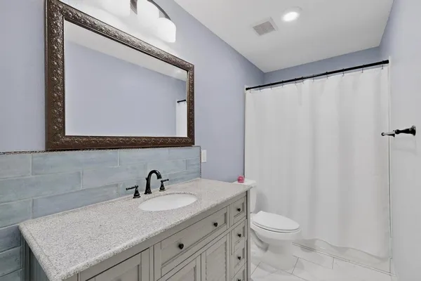 a bathroom with a granite countertop sink and a mirror