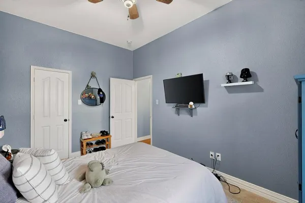 a bedroom with a bed and a flat tv screen on the wall