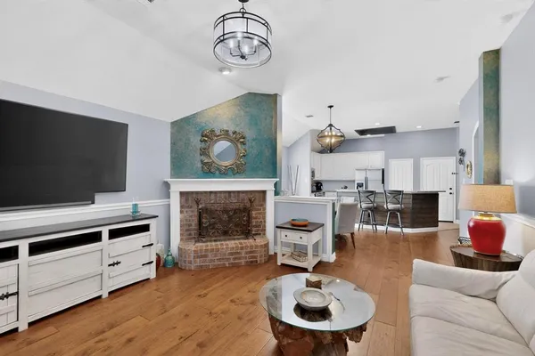 a living room with furniture a flat screen tv and kitchen view