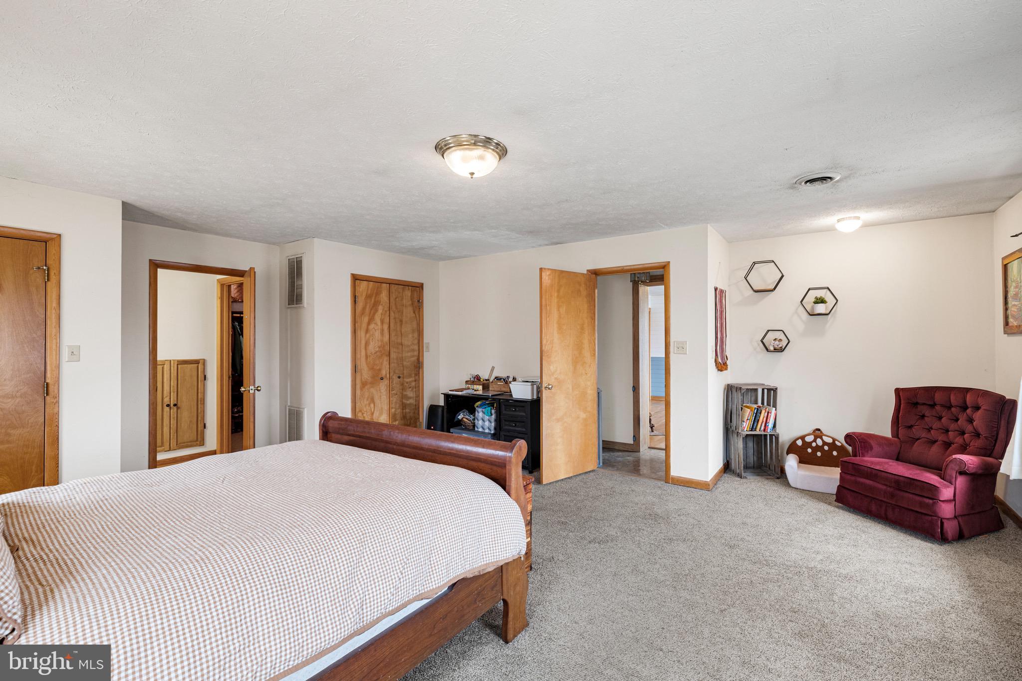 3360 Senedo Road Quicksburg, VA 22847 - Photo 11 of 58 a spacious bedroom with a bed and a couch