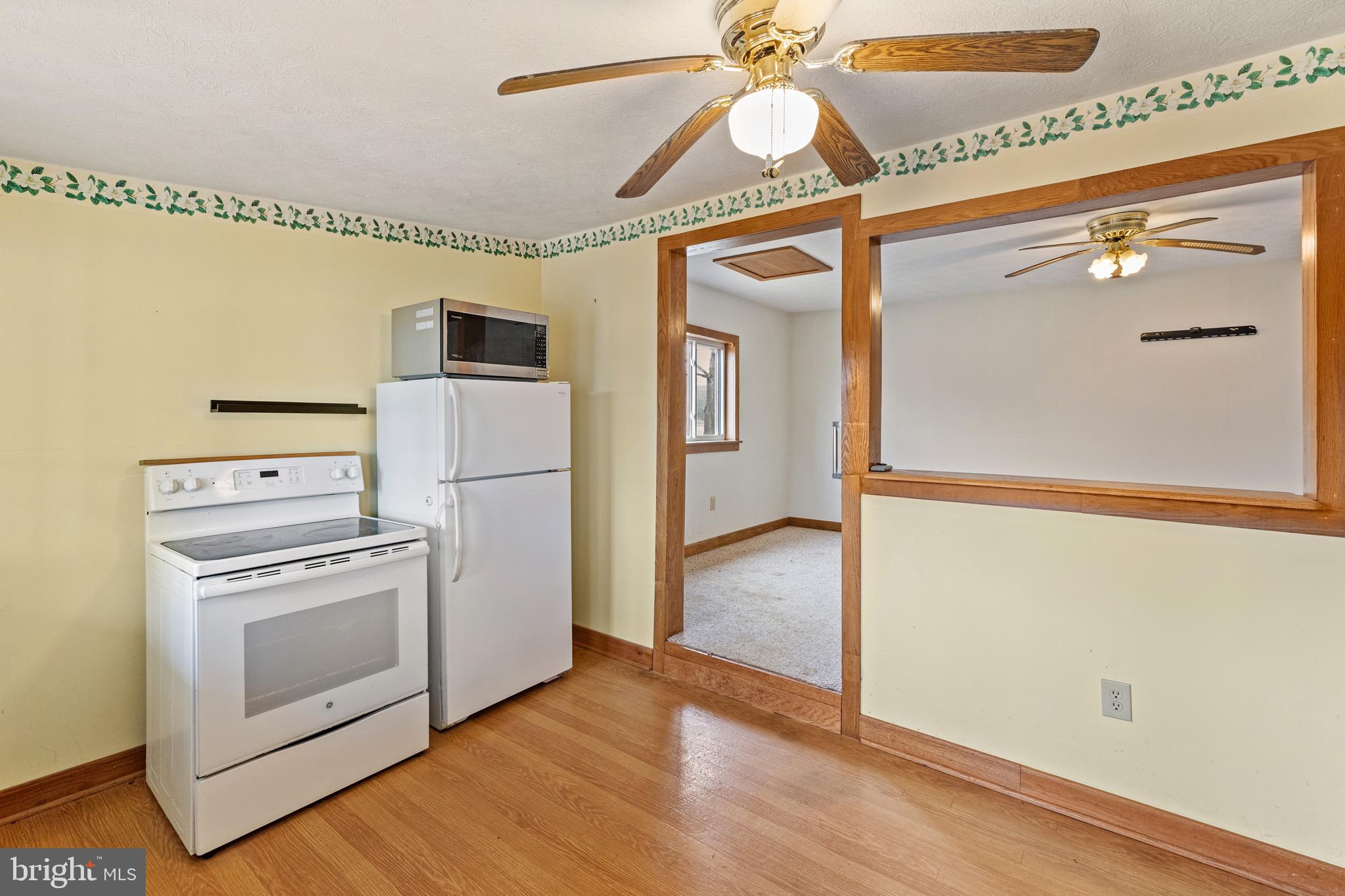 3360 Senedo Road Quicksburg, VA 22847 - Photo 40 of 58 a kitchen with a refrigerator a stove and a wooden floor