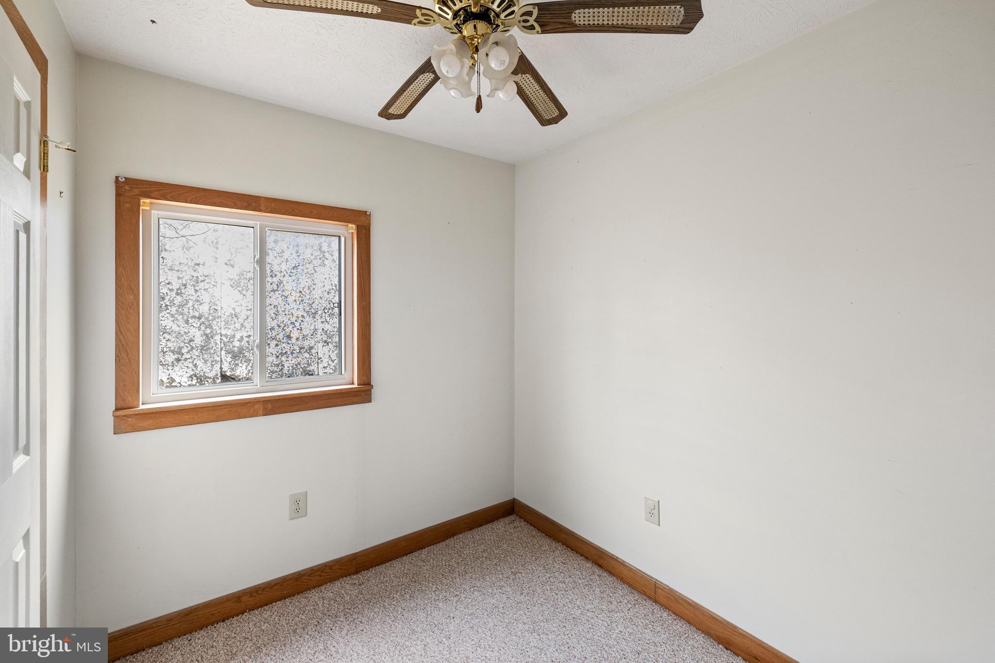 3360 Senedo Road Quicksburg, VA 22847 - Photo 45 of 58 an empty room with a window and a ceiling fan