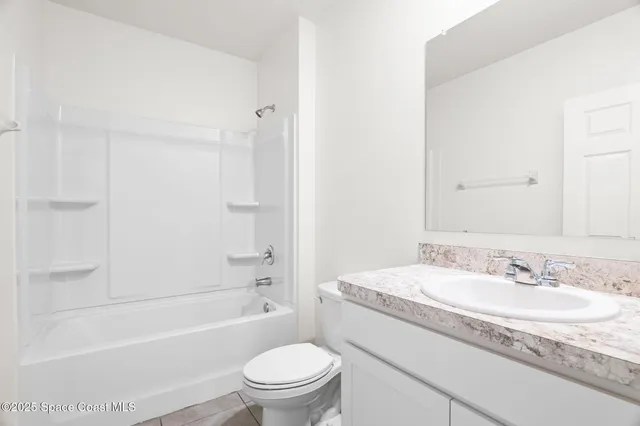 a bathroom with a granite countertop sink a toilet and a bathtub