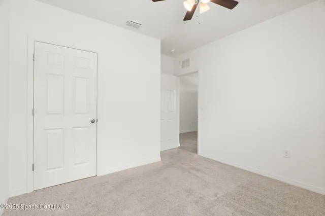 an empty room with view of a ceiling fan
