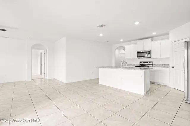 a kitchen with stainless steel appliances a refrigerator sink and microwave