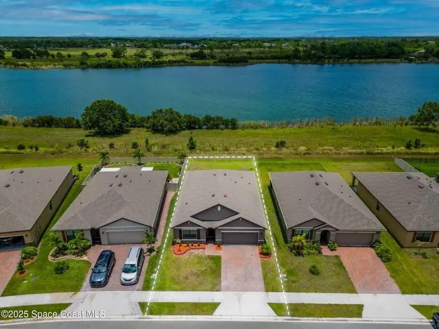 an aerial view of residential houses with outdoor space and lake view