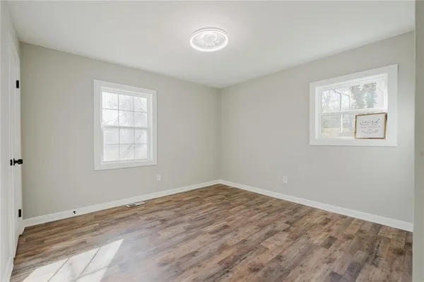 an empty room with windows and closet