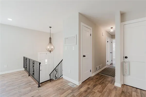 a view of a hallway with wooden floor and staircase