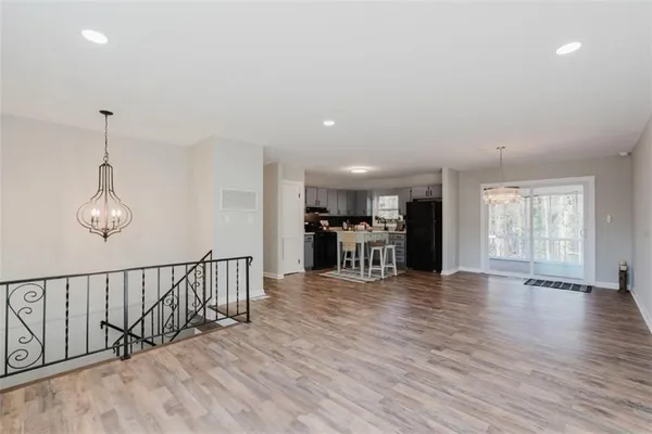 a view of a room with wooden floor lounge chair and windows