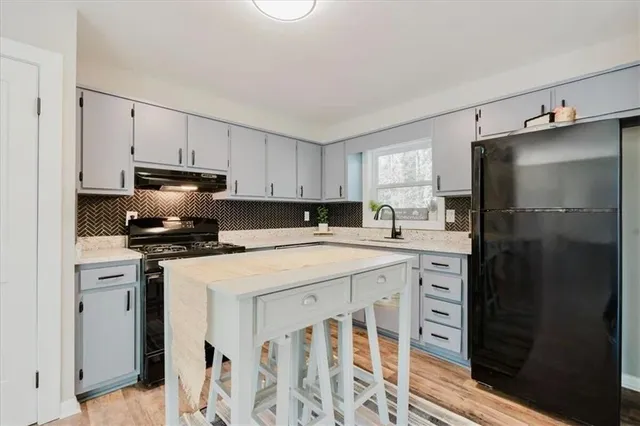 a kitchen with stainless steel appliances a stove a sink and a refrigerator