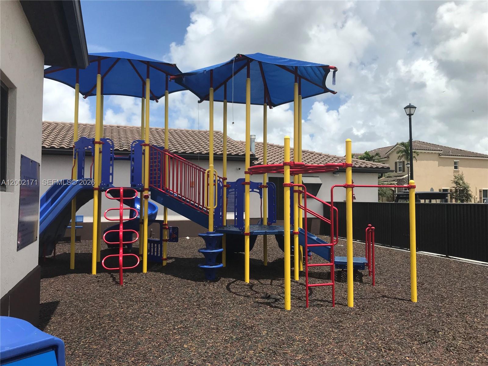 9515 Southwest 171st Place, Unit ANNEX Miami, FL 33196 - Photo 24 of 26 a view of a chairs and table in front of a building