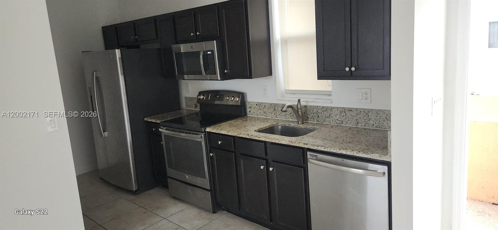9515 Southwest 171st Place, Unit ANNEX Miami, FL 33196 - Photo 4 of 26 a kitchen with a sink and a refrigerator