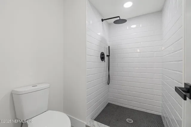 a bathroom with a toilet and a shower