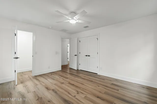 a view of an empty room with wooden floor