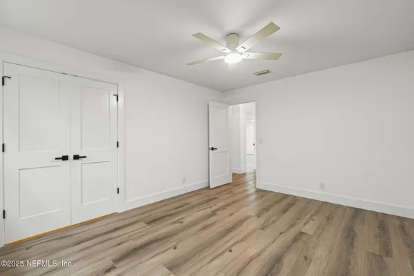 a view of an empty room with wooden floor