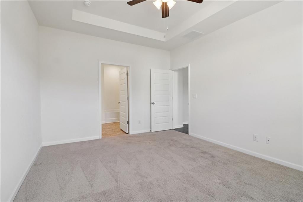 1729 Limousin Way Stockbridge, GA 30281 - Photo 12 of 26 an empty room with chandelier fan and windows