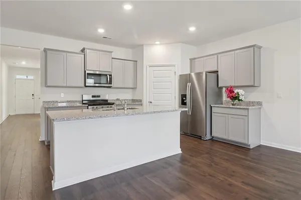 a kitchen with stainless steel appliances a refrigerator sink and microwave