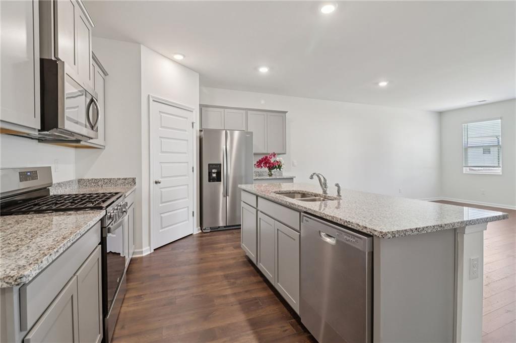 1729 Limousin Way Stockbridge, GA 30281 - Photo 9 of 26 a kitchen with stainless steel appliances granite countertop a sink stove and refrigerator