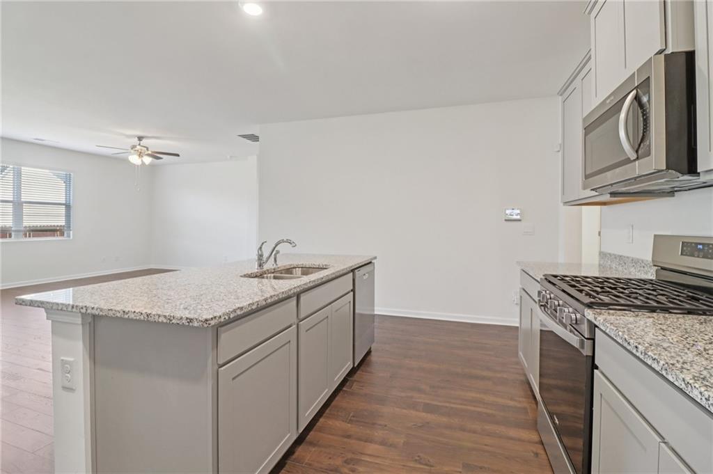 1729 Limousin Way Stockbridge, GA 30281 - Photo 10 of 26 a kitchen with stainless steel appliances granite countertop a sink stove and cabinets
