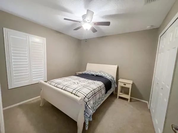a bedroom with a bed and a ceiling fan
