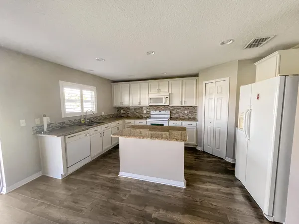 a kitchen with a refrigerator a sink and cabinets