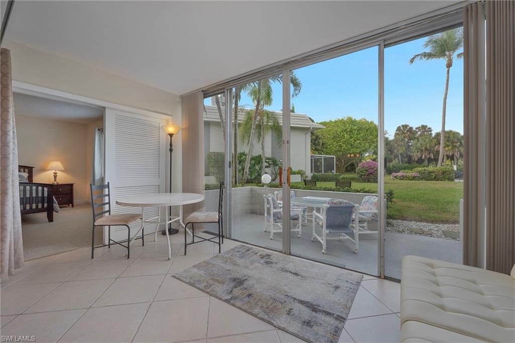 215 Cypress Way East, Unit C4 Naples, FL 34110 - Photo 11 of 15 a dining room with furniture and a floor to ceiling window